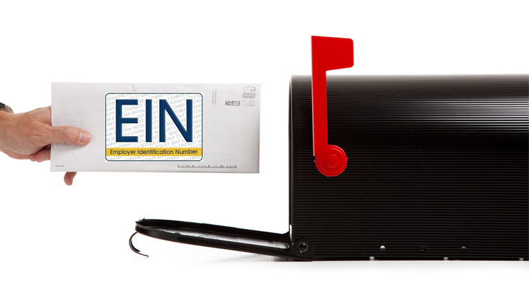 White envelope with EIN label going inside black mailbox