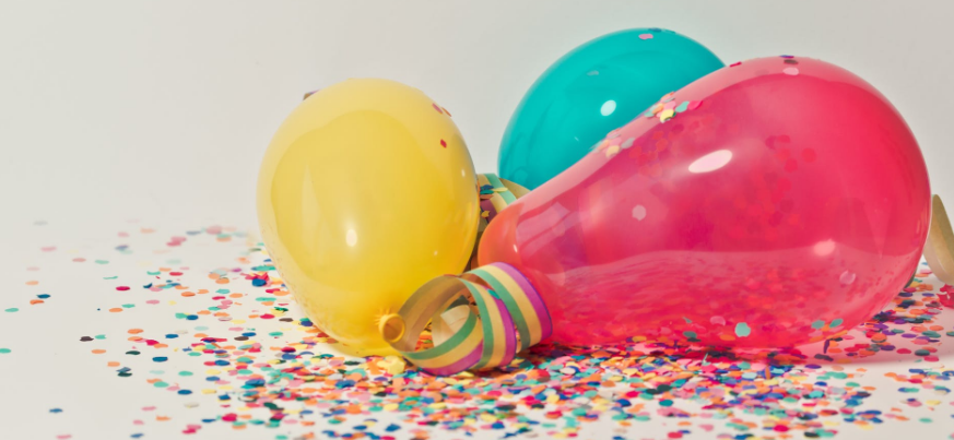 Pink, blue and yellow ballons with confetti