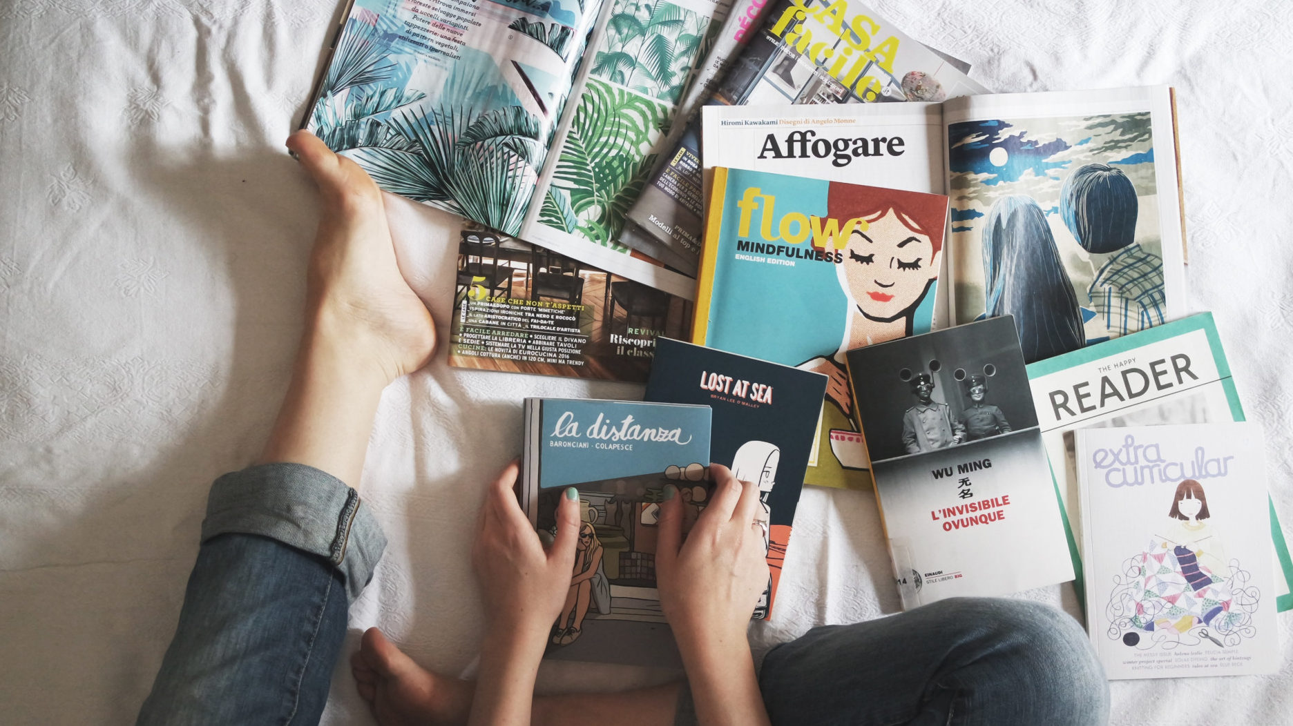 Flay lay of Woman Reading Magazines on Bed for choosing ecommerce products